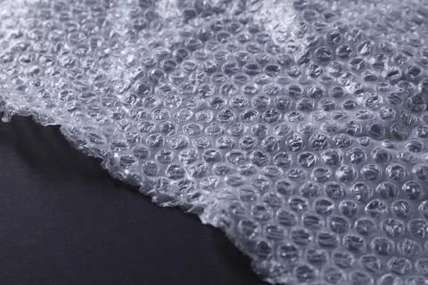 Transparent bubble wrap on black background, closeup. Space for text Stock Photos
