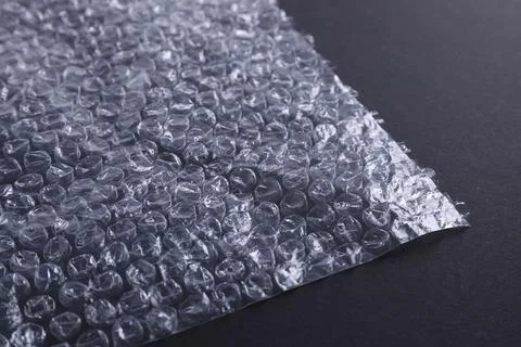 Transparent bubble wrap on black background, closeup Stock Photos
