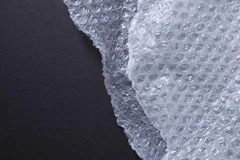 Transparent bubble wrap on black background, top view. Space for text Stock Photos