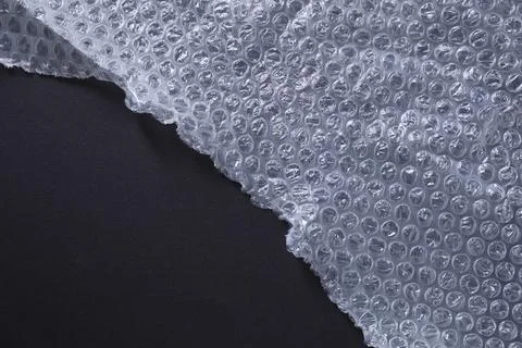 Transparent bubble wrap on black background, top view. Space for text Stock Photos