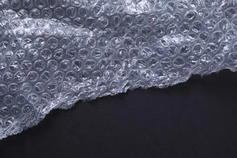 Transparent bubble wrap on black background, top view. Space for text Stock Photos