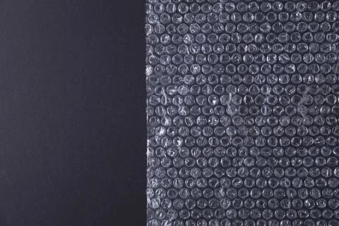 Transparent bubble wrap on black background, top view. Space for text Stock Photos