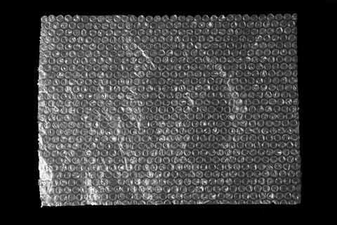 Transparent bubble wrap on black background, top view Stock Photos