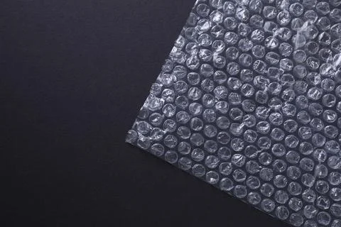 Transparent bubble wrap on black background, top view. Space for text Stock Photos