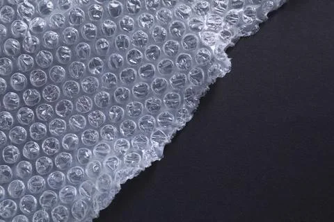 Transparent bubble wrap on black background, top view. Space for text Stock Photos