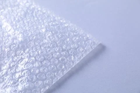 Transparent bubble wrap on gray background, closeup. Space for text Foto stock