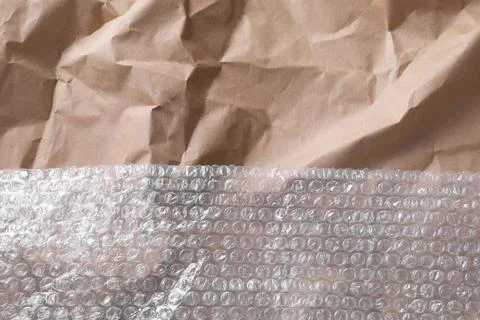 Transparent bubble wrap on kraft paper, top view. Space for text Foto stock