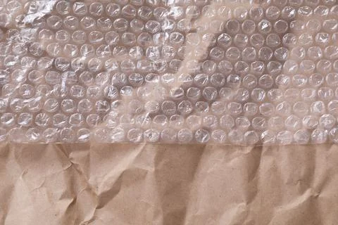 Transparent bubble wrap on kraft paper, top view. Space for text Foto stock