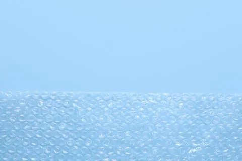 Transparent bubble wrap on light blue background, top view. Space for text Foto stock