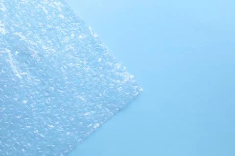 Transparent bubble wrap on light blue background, top view. Space for text Foto stock