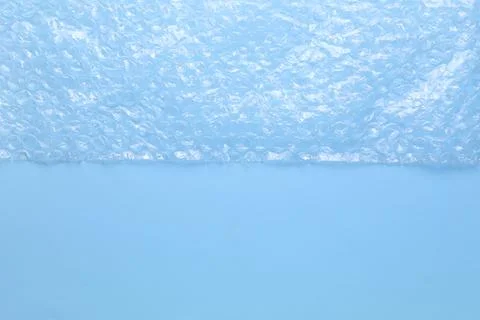 Transparent bubble wrap on light blue background, top view. Space for text Foto stock