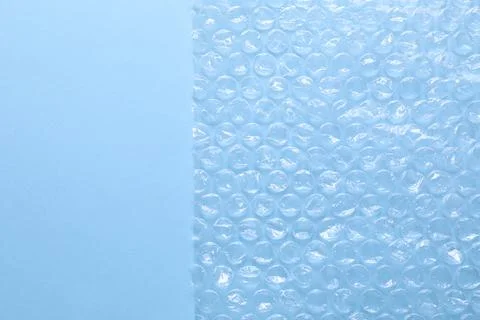 Transparent bubble wrap on light blue background, top view. Space for text Foto stock
