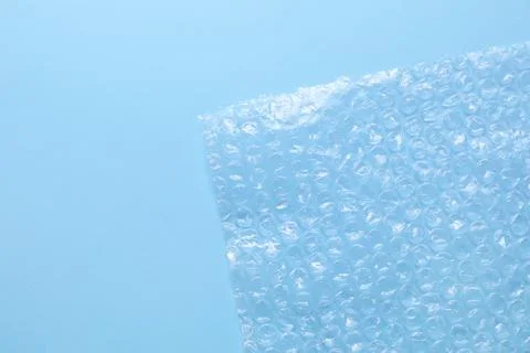 Transparent bubble wrap on light blue background, top view. Space for text Foto stock