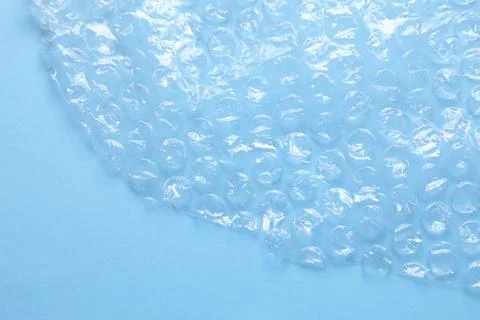 Transparent bubble wrap on light blue background, top view. Space for text Foto stock