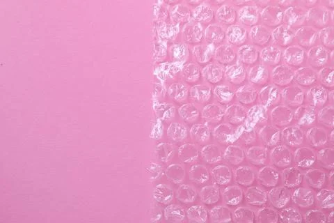 Transparent bubble wrap on pink background, top view. Space for text Stock Photos