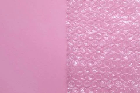 Transparent bubble wrap on pink background, top view. Space for text Stock Photos