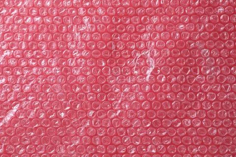 Transparent bubble wrap on red background, top view Stock Photos