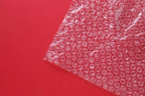 Transparent bubble wrap on red background, top view. Space for text Stock Photos