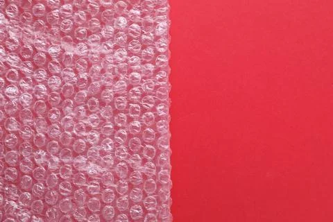 Transparent bubble wrap on red background, top view. Space for text Stock Photos
