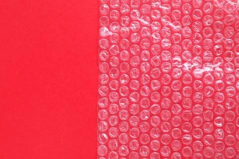 Transparent bubble wrap on red background, top view. Space for text Foto stock