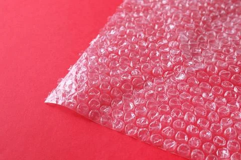 Transparent bubble wrap on red background, closeup Foto stock