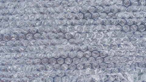 Transparent Bubble Wrap Shifts Across a Clean Pale Blue Surface, Creating a Seam Stock Footage 340609205