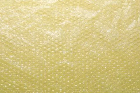 Transparent bubble wrap on yellow background, top view Stock Photos