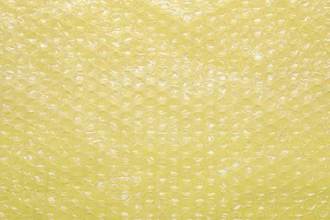 Transparent bubble wrap on yellow background, top view Stock Photos