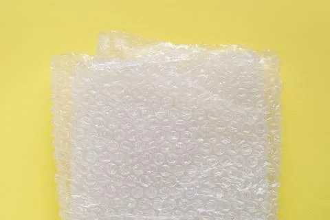 Transparent bubble wrap on yellow background, top view Stock Photos