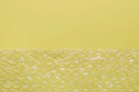Transparent bubble wrap on yellow background, top view. Space for text Foto stock
