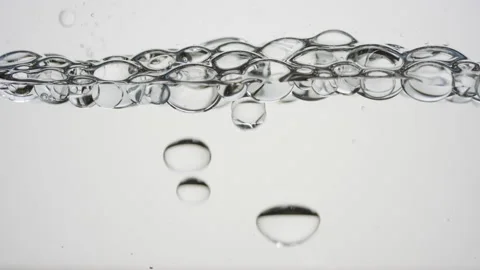 Transparent bubbles float to the surface on grey background Video stock 233792592