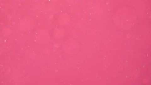 Transparent bubbles slide along pink smaller ones, moving them on a pink Stock Footage 220882192