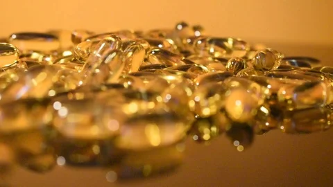 Transparent capsules on a gold background Stock Footage 118922695
