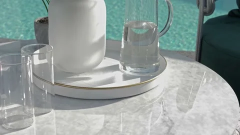 Transparent carafe of clean water on a table by the pool. Stock Footage 220772071