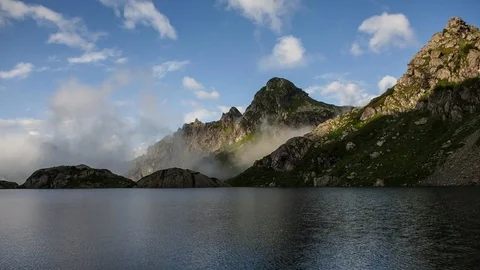 Transparent clouds rolling over the rgand mountain lake timelapse Stock-Footage 88192390