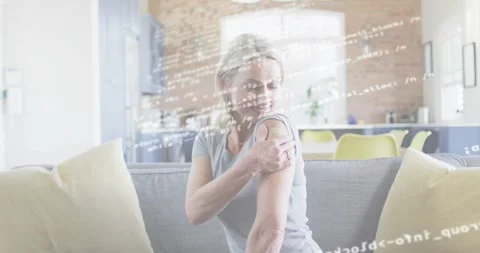 Transparent code overlay fading and revealing woman massaging arm for easing Stock Footage 318689729