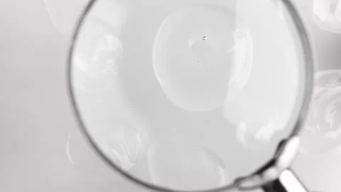 Transparent cosmetic drops on a light background top view. Video stock 222752234