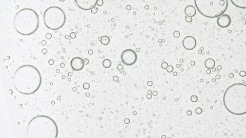 Transparent cosmetic gel fluid with molecule bubbles oil distribution on a white Stock Footage 276995295