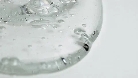 Transparent Cosmetic Gel Fluid  With Tiny Bubbles Slowly Flowing On White Stock Footage 140564383