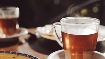 Transparent cup of hot black tea and breakfast on the blurred background on the Stock Footage 85660413