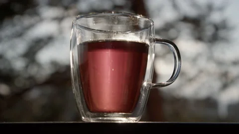 Transparent cup with tea against the background of the sun.4K, slow motion Video stock 173776888