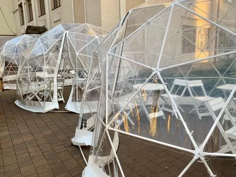 Transparent dining pods create a cozy atmosphere for guests at a restaurant's Stock Photos
