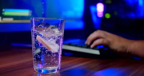 Transparent drink with lemon next to professional esports video gamer Stock-Footage 160557100