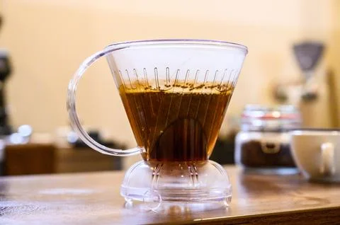 Transparent dripper showcasing pour over coffee brewing process Stock Photos