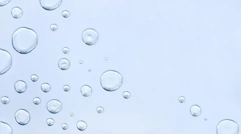 Transparent drops close-up on a light blue background. Top view, place for text Stock-Fotos