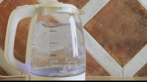 A transparent electric kettle on the table begins to boil. Medium shot. 库存影片 332164524
