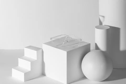 Transparent eyeglasses presented on a set of white 3d shapes Stock Illustration