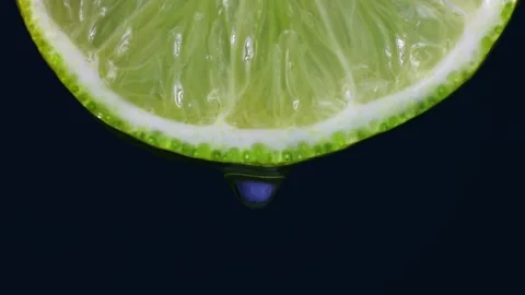 Transparent gel drop falling down from bright green lime slice Stock Footage 270478731