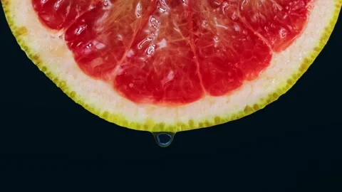 Transparent gel drop falling down from bright red grapefruit slice Stock Footage 270478965