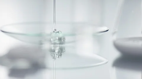 Transparent gel is falling onto a glas plade in a laboratory with a slow focu Vidéo 100592852